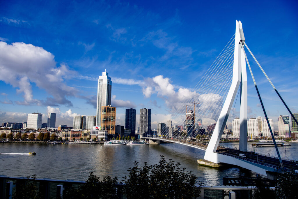 Zicht vanaf het nhow Rotterdam hotel op de Erasmusbrug met De Zalmhaven en de skyline van Rotterdam.